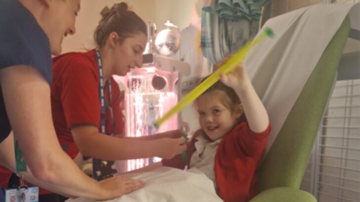 Frankie having a blood test with a sensory toy to distract her